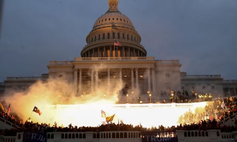 An explosion caused by a police munition is seen while supporters of then-president Donald Trump gather outside the US Capitol building in Washington DC on 6 January 2021