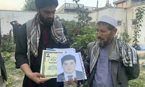 Mohammed Jan Sultani’s father, Ali, right, looks at his son’s Taekwondo championship certificates along with picture of him.