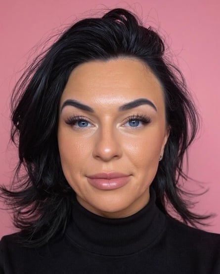 A portrait of a woman with dark hair in front of a pink background