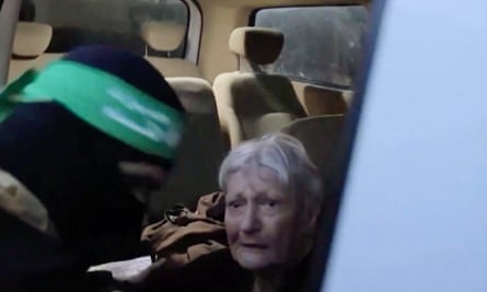 An image grab from a video released by the Hamas Media Office shows a member of its Al-Qassam Brigades leading Yaffa Adar to Red Cross officials in Gaza on 24 November.