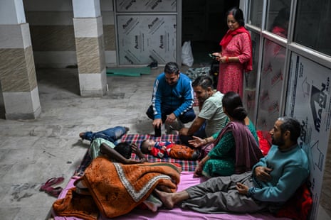 Residents take shelter in the basement of a building during overnight artillery shelling in the main town of Poonch district on Friday