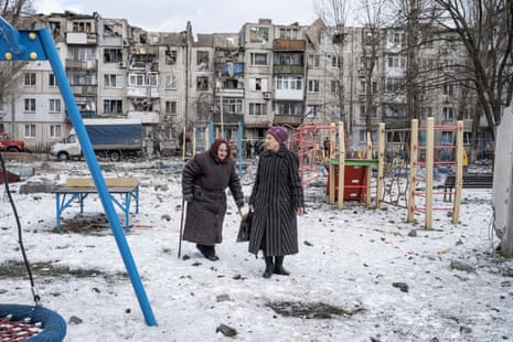 Women walk on a playground after an apartment block was heavily damaged by a missile strike in Pokrovsk, Donetsk region.
