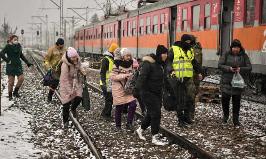 Newly arrived refugees in Medyka, Poland, board a train for Krakow