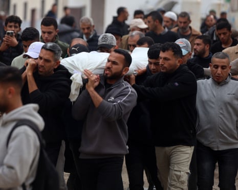 Mourners carry the body of a Palestinian that medics say was killed in an Israeli strike, during a funeral procession at Al Shifa Hospital in Gaza City, Gaza