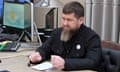 Ramzan Kadyrov sitting at a desk with a notebook in front of him