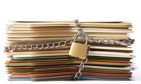 Stack of file folders bound up with a chain and padlock