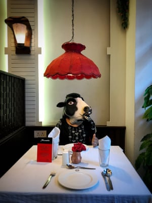 A woman dressed as a cow at a diner.