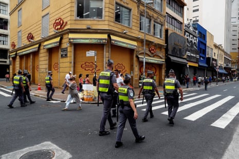 Members of Brazilian police patrol in front of closed stores due to the coronavirus pandemic at 25 de Marzo street, the major commerce centre in São Paulo, Brazil, 26 December 2020.