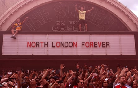 Arsenal fans celebrate their team during the street parade in north London