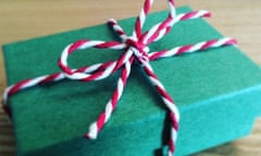 A green gift box with a red and white tie