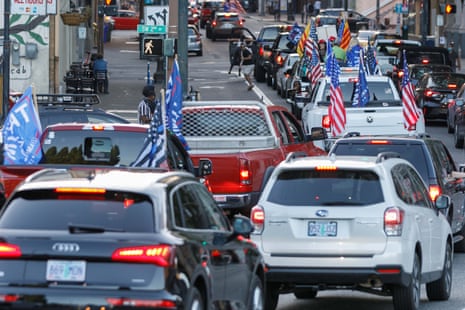 Pickup trucks and cars full of flag-waving Donald Trump supporters as they snarl traffic and parade through downtown Portland, Oregon on August 29, 2020.