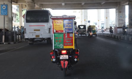 A motorbike with a box on the back driving through an underpass
