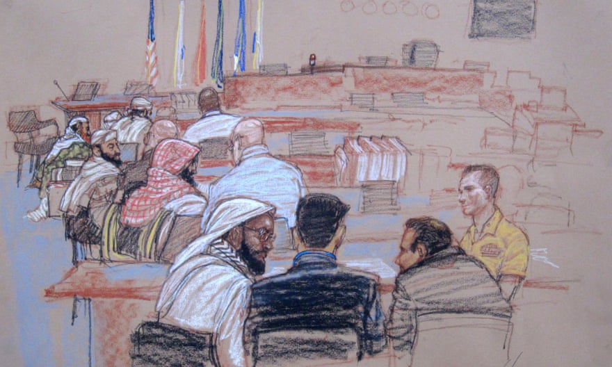 Defendants shown speaking with their lawyers during a break in proceedings