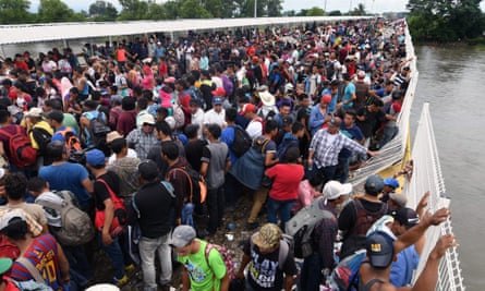 Honduran migrants taking part in a caravan to the US wait to cross to Mexico.