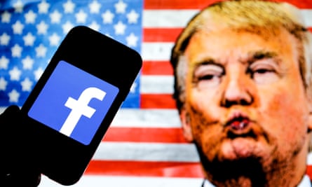 In this photo illustration the Facebook social media app company logo seen displayed on a smartphone, face of Donald Trump and the United States of America flag seen in the background. Company logo on a smartphone