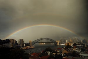 A rainbow and rain clouds are seen over the Sydney Harbour Bridge