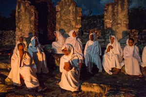 Igatu, Brazil. Catholic women dressed in white take part in the Terno das Almas procession at the Chapada Diamantina National Park. During Holy Week participants make a nightly pilgrimage through the village, praying and singing for the souls of their dead