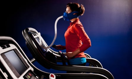 Wanita berlari di atas treadmill memakai masker untuk mengukur kadar oksigen