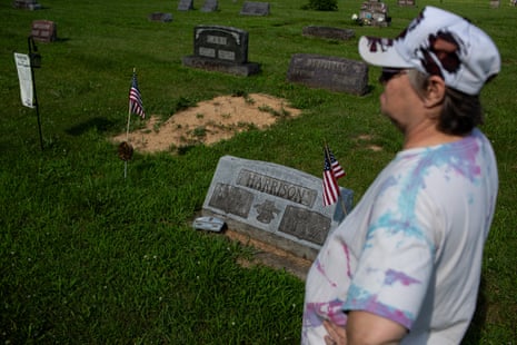 A woman at a burial plot with small US flags.