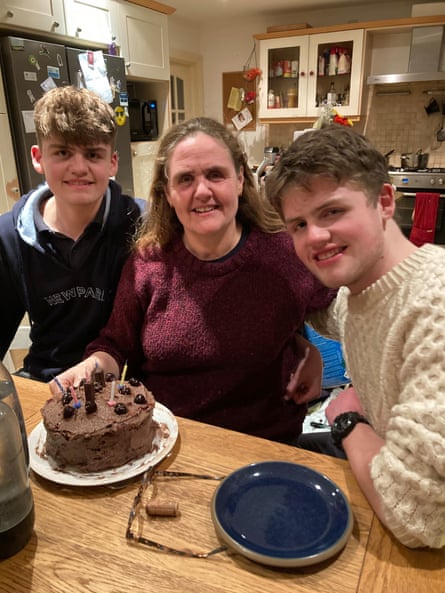 Mary Ann Kenny sits at her kitchen table with her chocolate birthday cake and her two sons.