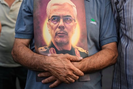 An Iranian man holds a poster of Mohammad Bagheri, the chief of staff of Iran’s armed forces, who was killed in an Israeli strike.