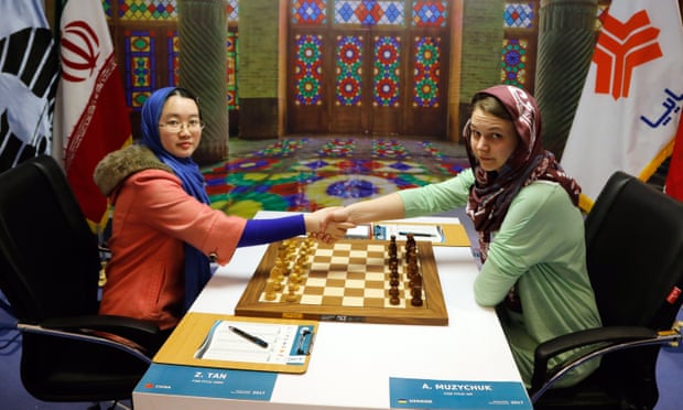 Chinese player Tan Zhongyi (left) shakes hands with Anna Muzychuk (right) of Ukraine at a championship in Iran 