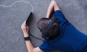 Boy using cell phone on floor
