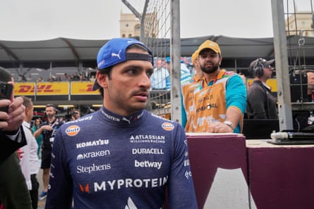 Williams driver Carlos Sainz emerges from the crowded paddock at the starting grid for the Azerbaijan Grand Prix in September