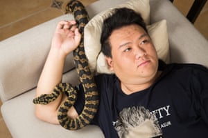Huang Jiachen, 20, a snake collector and exotic species breeder with his pet python at home in Beijing