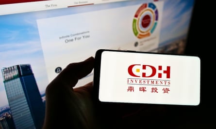 A person holding a smartphone with a logo of Chinese investment company CDH Investments on the screen