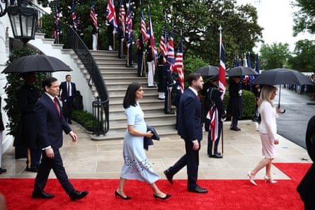 A man and woman walk down a red carpet
