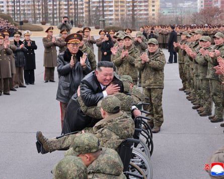 Kim with returning soldiers from the North Korean engineering regiment in an image released by the official Korean Central News Agency