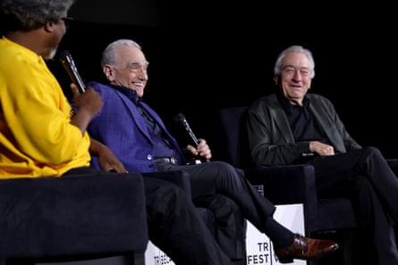 three men sit on stage with microphones