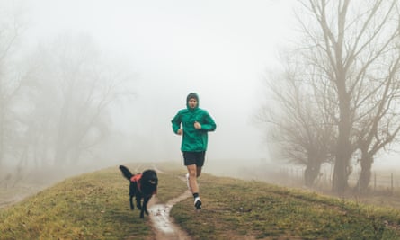 Active young man jogging with his dog.