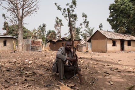 A vigilante sits on the ground with his gun in the village of Bakin Kogi, in Kaduna State, north-west Nigeria.