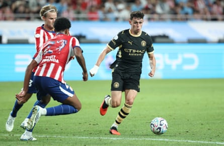 Phil Foden of Manchester City competes for the ball with Morten Hjulmand of Atlético Madrid during their preseason friendly