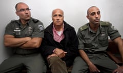 Israeli nuclear whistleblower Mordechai Vanunu, centre, sits between two prison guards as he waits in a courtroom before a hearing in Jerusalem.in 2010 for violating the conditions of his 2004 release.