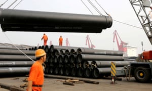 Workers in China loading huge steel pipes