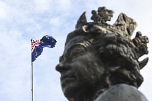 The Australian flag flies next to a statue of her Majesty the Queen Elizabeth II at Parliament House in Canberra.