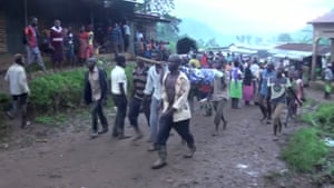 Residents bear bodies away from the scene of a landslide in Bududa, Uganda