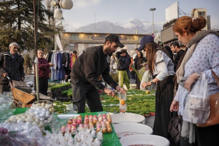 A vendor places goldfish into a bag for the customer.