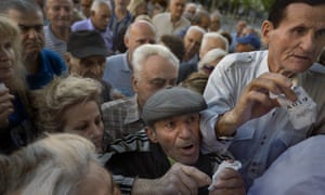 Pensioners holding their queue numbers try to enter into a bank in Athens.