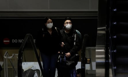 Travellers wearing masks arrive on a direct flight from China at Seattle-Tacoma International airport.