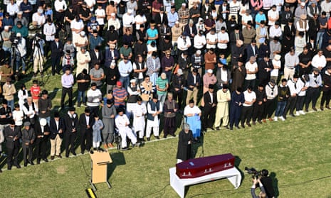 Imam prays over coffin with mourners behind him