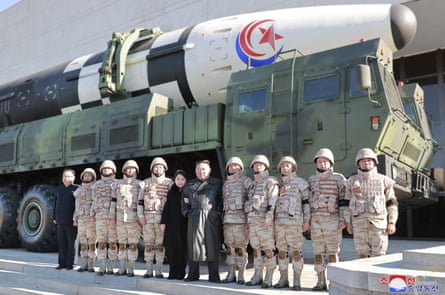 Kim Jong-un y su hija posan con soldados para una foto frente a lo que los medios estatales dicen que es un misil balístico intercontinental Hwasong-17, en un lugar no identificado.