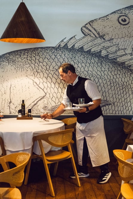 Travolta Restaurant, Athens. A waiter lays a table.