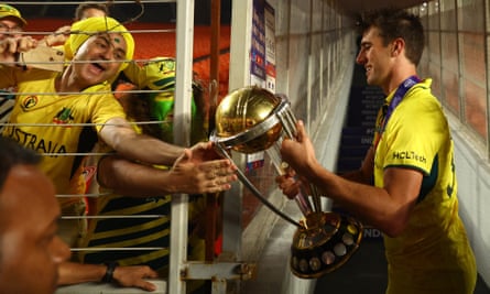 Australia’s Pat Cummins celebrates with fans and the trophy after winning the ICC Cricket World Cup.