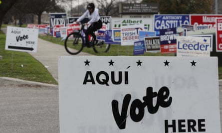A cyclist passes election signs near an early voting site in San Antonio, on 18 February 2020.