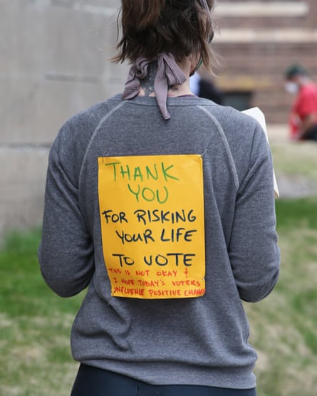 person wears sign saying thank you for risking life to vote