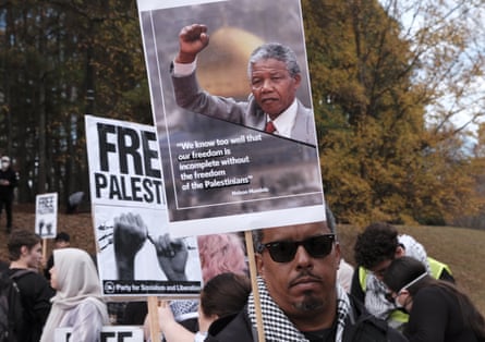 A protester holds a sign with a quote from Nelson Mandela during a funeral prayer and march in Atlanta for the victims of Israel’s siege on Palestine on 3 December 2023.
